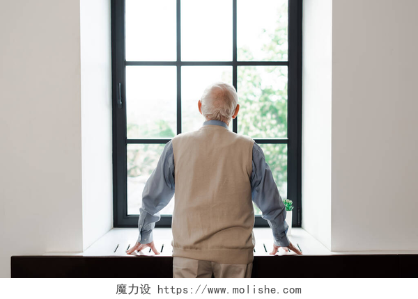 老人站在窗边看向远方隔离期间站在窗边的孤独老人的背影
